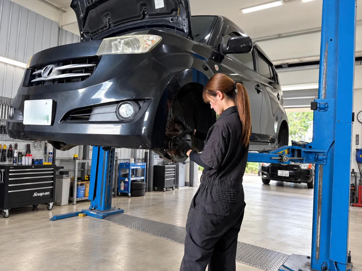リフトに上げた車両を点検する整備作業