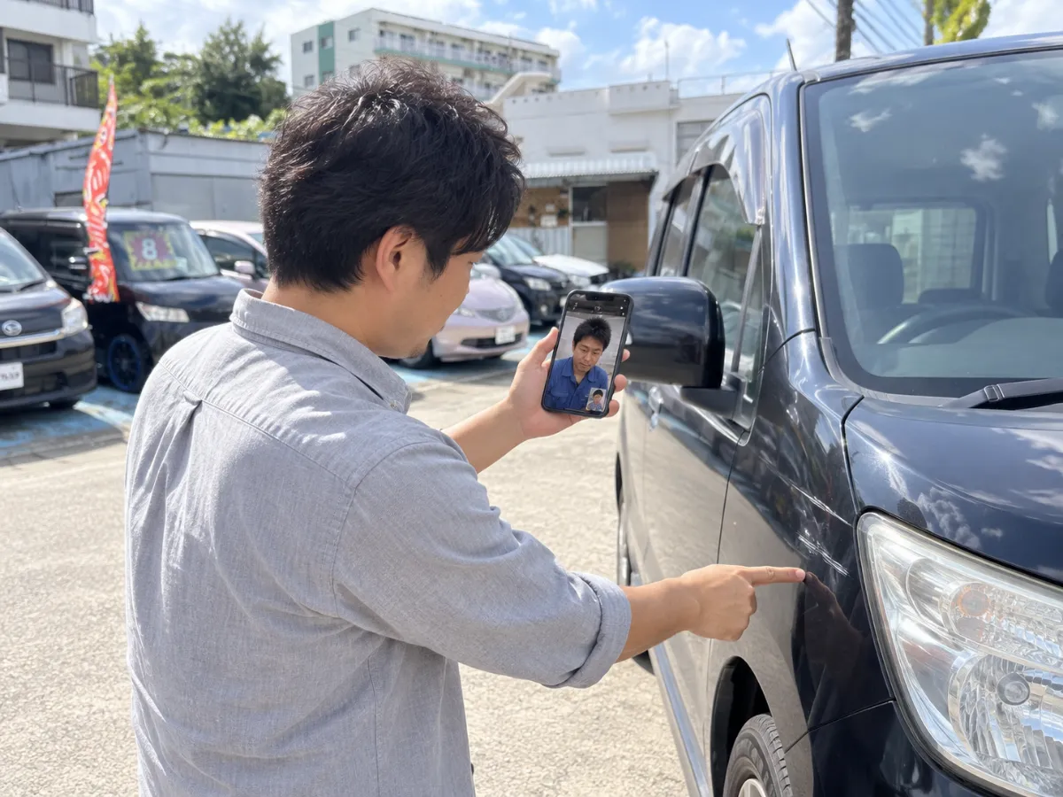 スマートフォンで車の状態を見せながら相談する様子